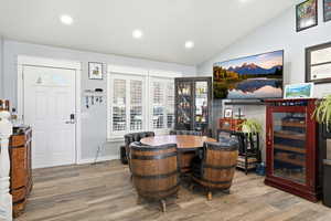 Home office with recessed lighting, wood finished floors, lofted ceiling, and beverage cooler