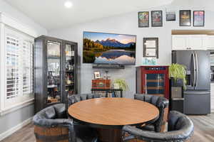Dining space featuring wood finished floors and lofted ceiling