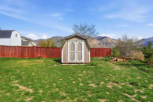 View of shed featuring a mountain view and a fenced backyard