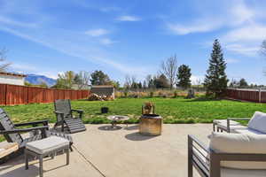 Fenced backyard featuring a patio, a mountain view, and outdoor furniture