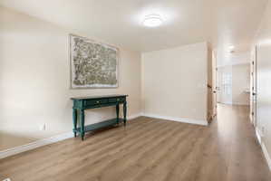 Hall with light wood-style floors and baseboards