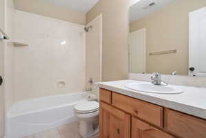 Bathroom featuring a single vanity with wood cabinetry, a laminate countertop, and an integrated oval sink