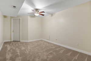 Carpeted room featuring a ceiling fan with light fixture, recessed lighting, and a paneled door with brass hardware