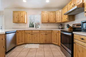 Kitchen with stainless steel appliances, light countertops, light wood finish cabinetry, light tile patterned flooring, and recessed lighting