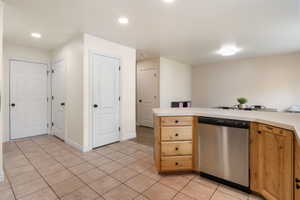 Kitchen featuring light countertops, dishwasher, light tile patterned floors, recessed lighting, and a peninsula