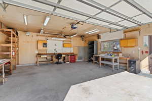 Large, detached garage with a workshop area with work benches and lots of shelving