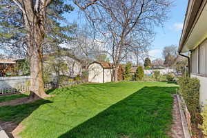 Fenced backyard with a storage shed