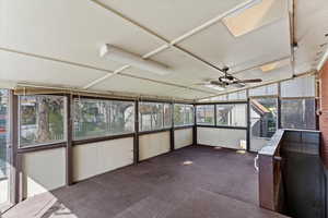 Unfurnished sunroom featuring ceiling fan and lofted ceiling