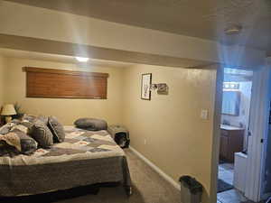 Carpeted bedroom featuring a textured wall and a textured ceiling