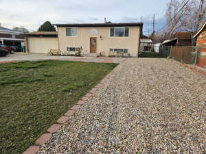 Split foyer home with driveway, a front yard, and an attached garage