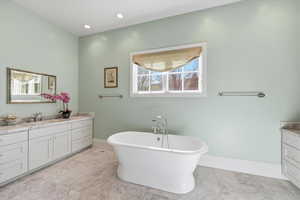 Master bath featuring twin vanities, a soaking tub, and walk-in shower