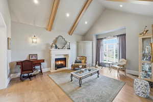 Living area featuring quarter sawn white oak flooring, vaulted ceiling, and fireplace