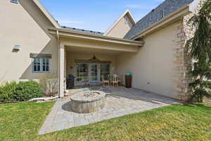 View of back patio, with concrete pavers and fire pit