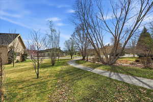 Green space with walking path and recirculating stream and pond adjacent to back yard extends the secluded feeling