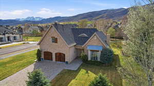 View of front of house featuring stone siding, a chimney, and a front yard