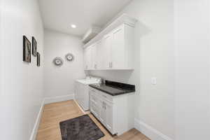 Laundry room featuring cabinet space, washing machine and dryer, and recessed lighting