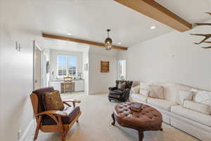 Living room featuring beamed ceiling, light colored carpet, and recessed lighting