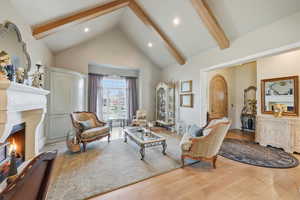 Living area featuring quarter sawn white oak flooring, vaulted ceiling, and fireplace