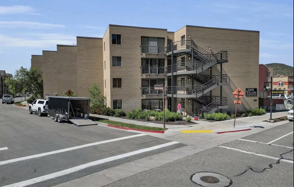 View of apartment building / complex featuring uncovered parking