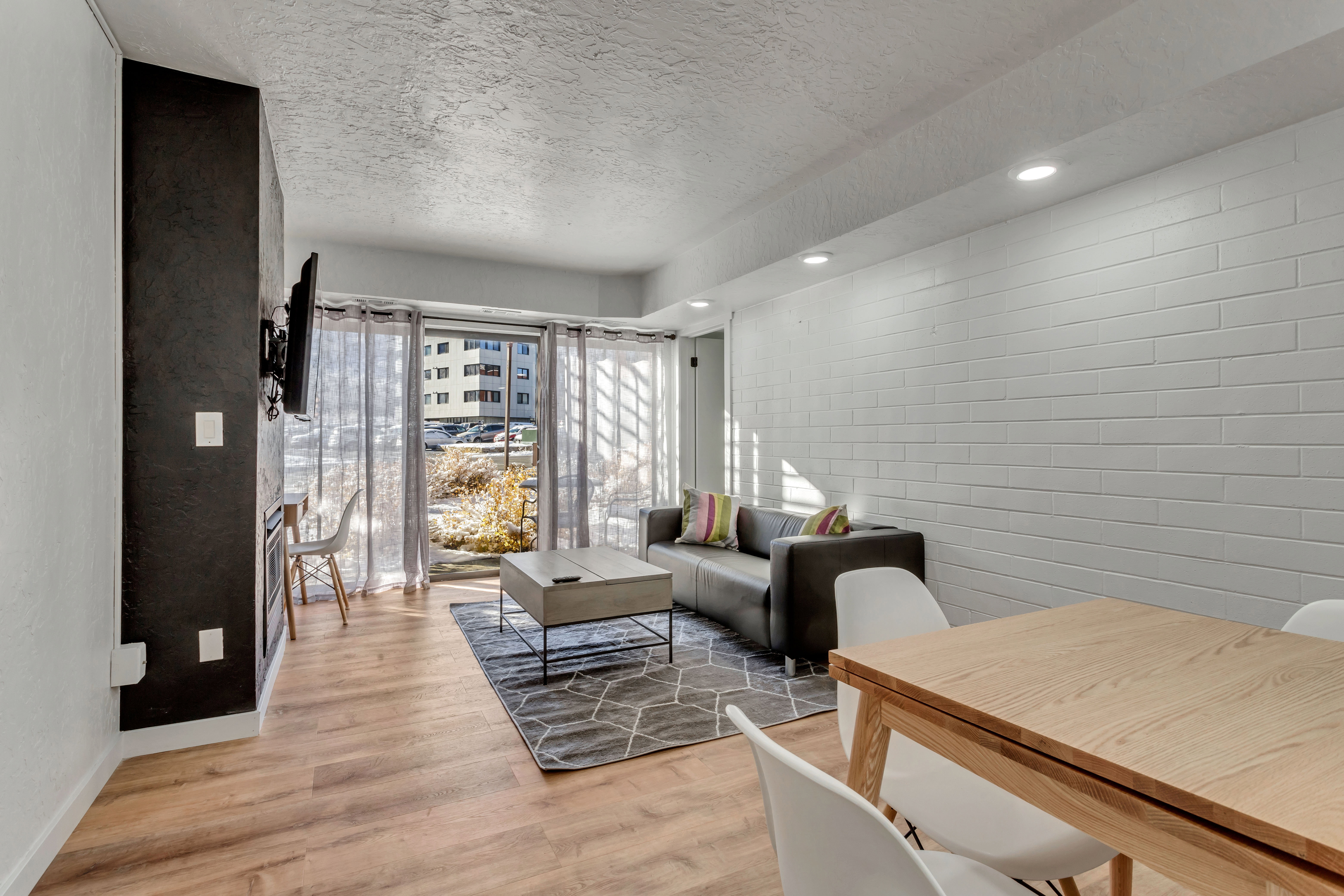 Living room featuring light wood-style flooring, a textured ceiling, and recessed lighting