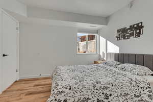 Bedroom with a textured wall and light wood finished floors