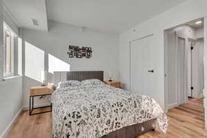 Bedroom featuring light wood-style flooring and a textured wall
