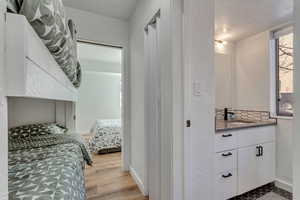 Bedroom with a textured wall and light wood-type flooring