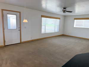 Entrance foyer featuring light colored carpet and a ceiling fan