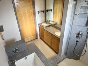 Bathroom featuring double vanity and curtained shower