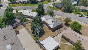 Aerial view of a residential property featuring a brick exterior structure with a light-colored roof