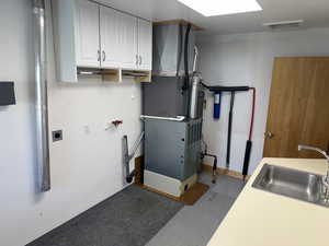 Utility room featuring a sink and heating unit