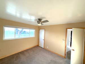 Unfurnished bedroom with light carpet and a ceiling fan