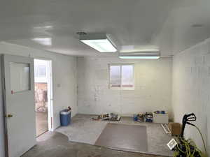 Unfurnished room with concrete floors and concrete block wall