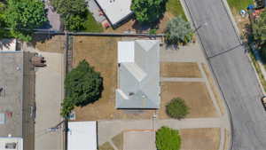 Single-story residential structure with a light-colored shingle roof, positioned on a corner lot