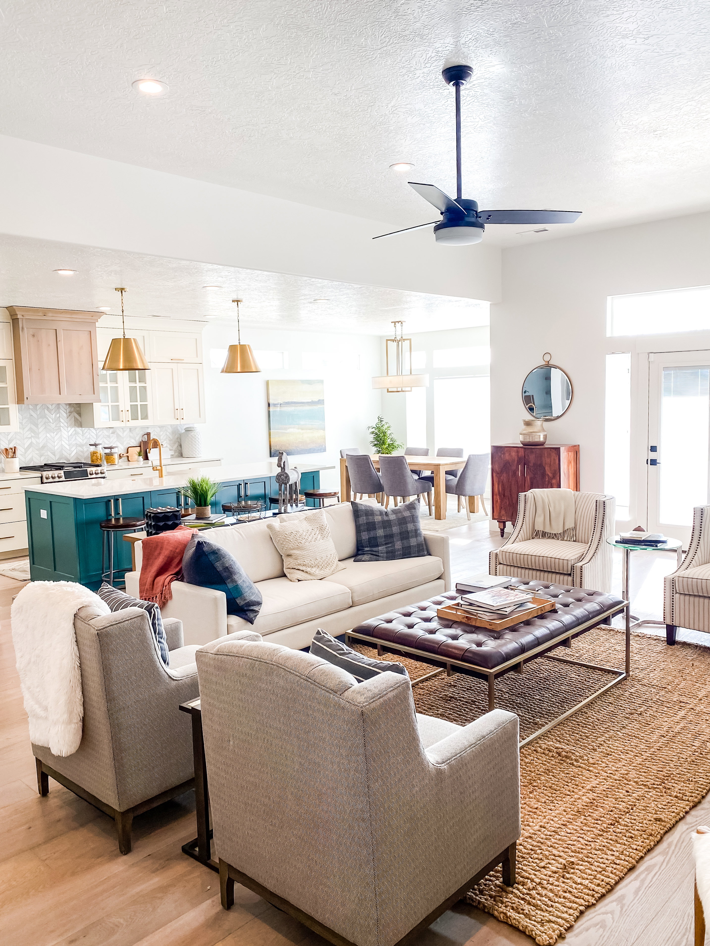 Living room with a ceiling fan, light wood-style floors, and a textured ceiling