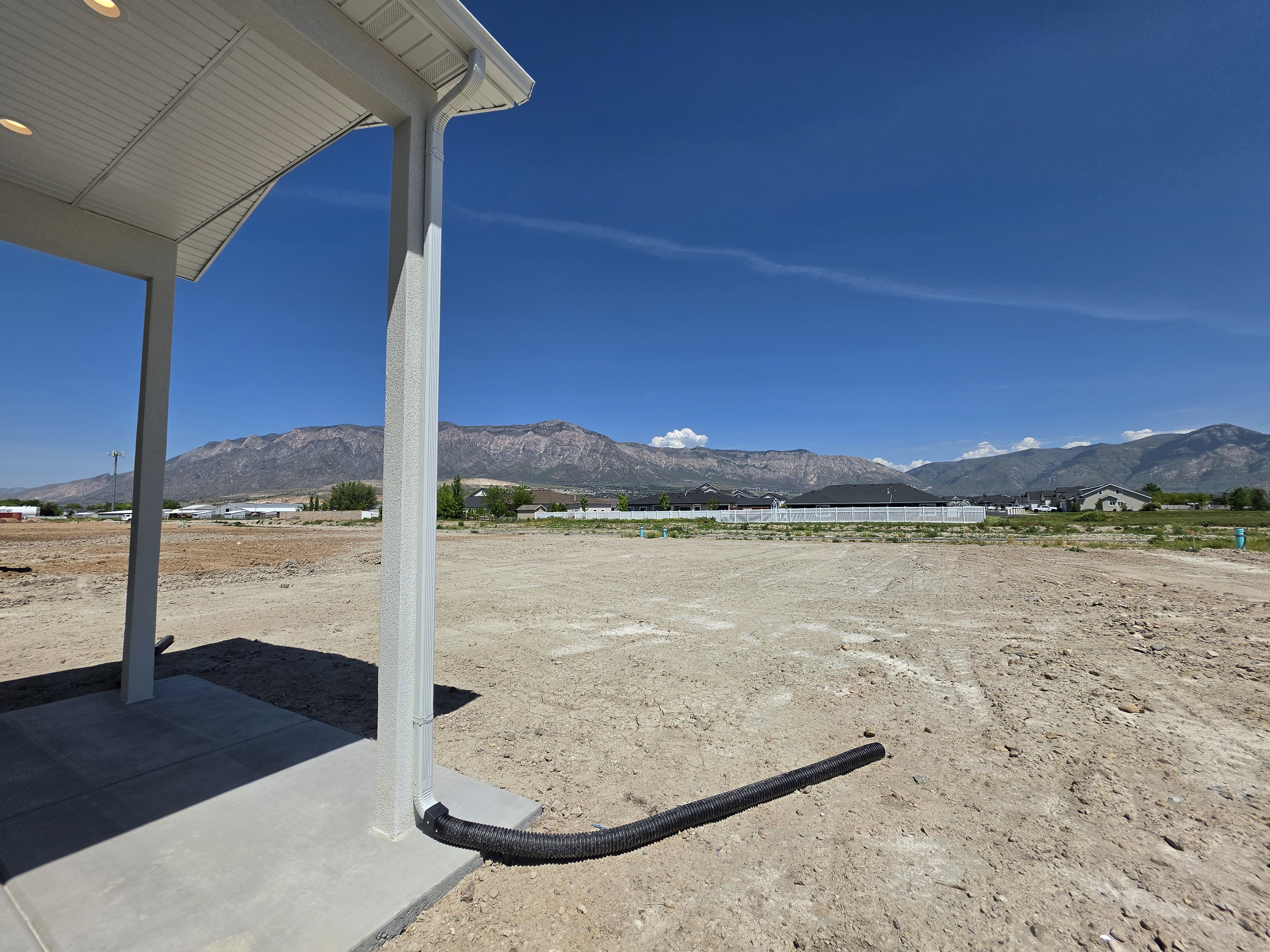 Expansive lot featuring mountain scenery and a covered patio area with recessed lighting