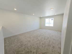 Carpeted empty room with baseboards and recessed lighting