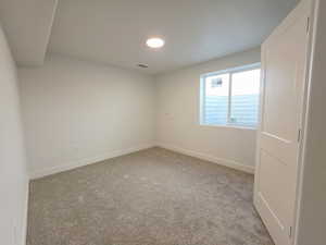 Carpeted empty room with baseboards