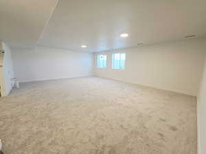 Below grade area featuring light colored carpet and recessed lighting