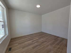 Empty room featuring dark wood-style flooring and baseboards