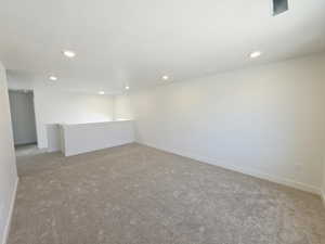 Carpeted empty room with baseboards and recessed lighting