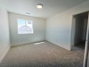 Empty room featuring light colored carpet and baseboards