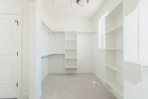 Walk in closet featuring light colored carpet
