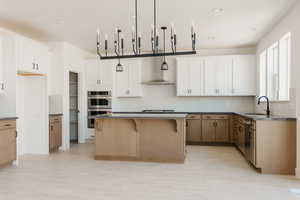 Kitchen with a breakfast bar, a center island, double oven, decorative backsplash, and dual tone cabinetry