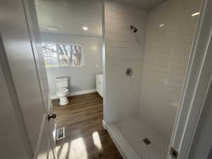Bathroom with dark wood finished floors, a shower stall, vanity, and recessed lighting