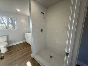 Full bathroom with a shower stall, dark wood-style floors, vanity, and recessed lighting