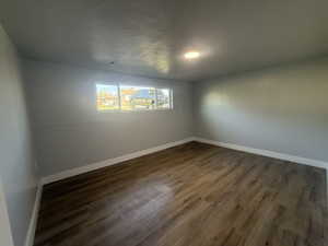 Spare room featuring dark wood-style floors and a textured ceiling