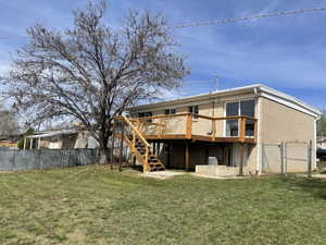 Rear view of property featuring a gate, a fenced backyard, and a deck