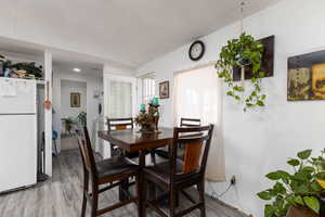 Dining space with light wood-style floors, a textured ceiling, and washer / clothes dryer