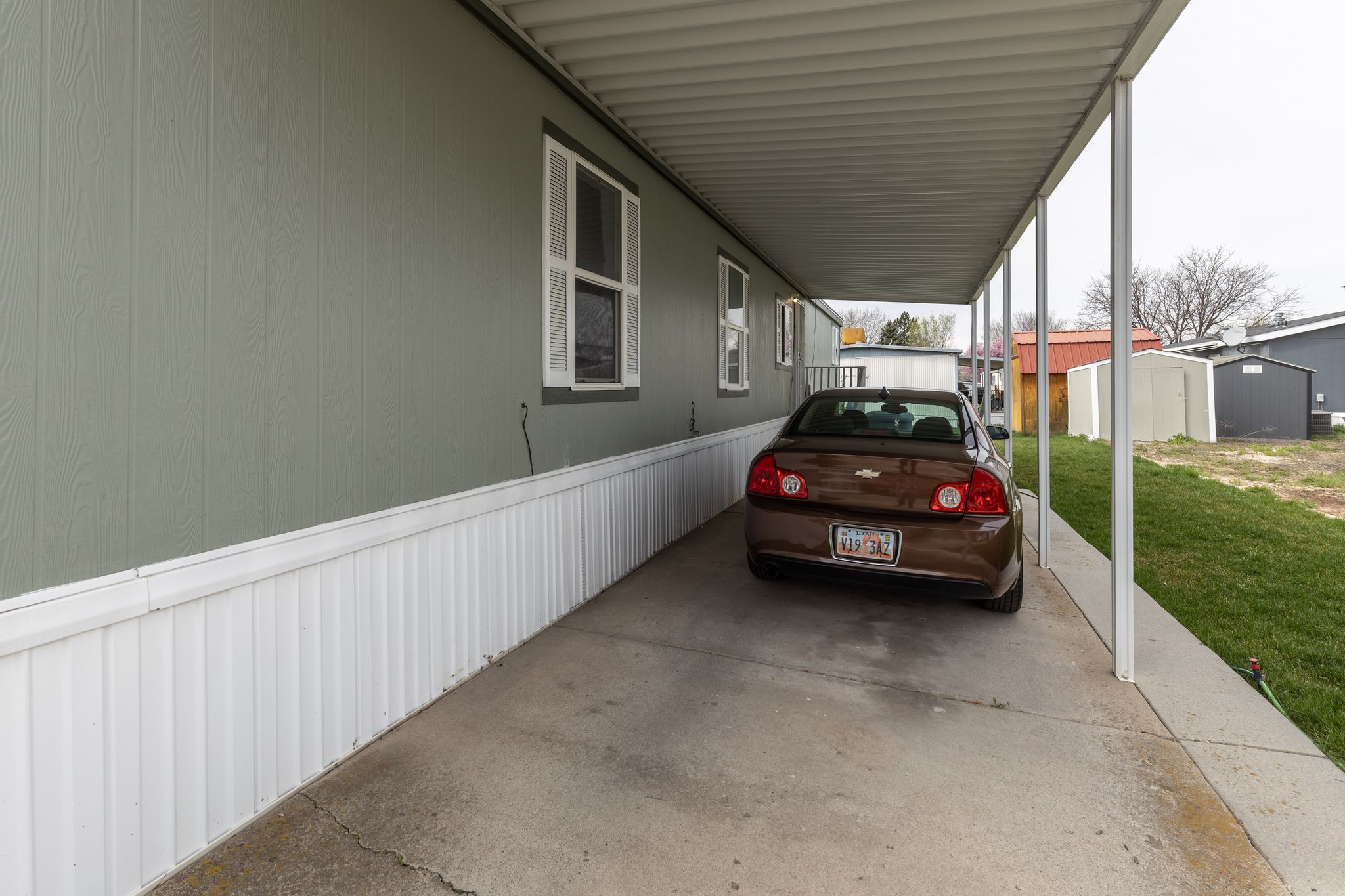 View of parking with a carport and a storage unit